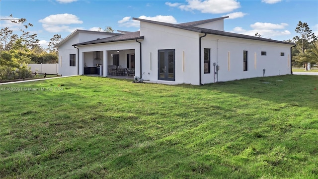 back of house featuring a patio area, a lawn, and french doors