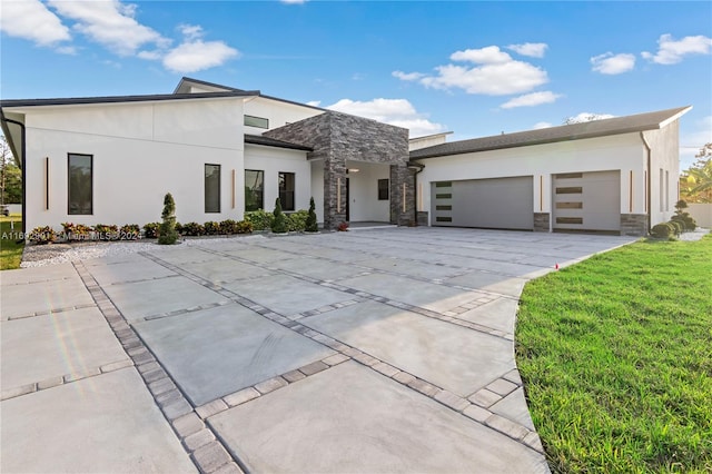 contemporary home with a garage and a front lawn