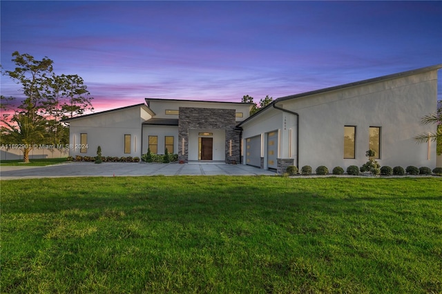 contemporary home with a garage and a yard