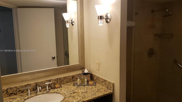 bathroom featuring a shower and vanity