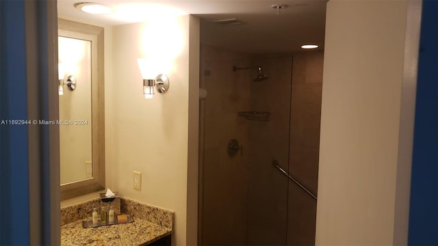 bathroom with vanity and a tile shower