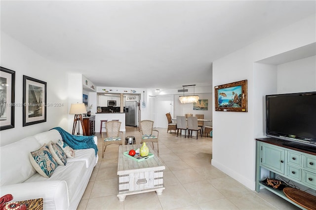 tiled living room featuring a notable chandelier