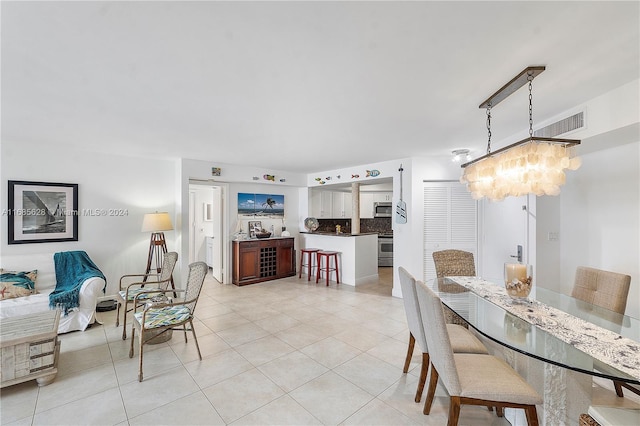 tiled dining area featuring a notable chandelier