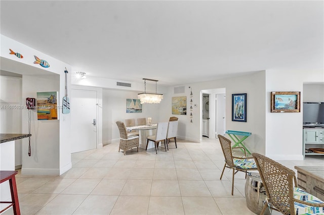 dining room with light tile patterned floors and a notable chandelier