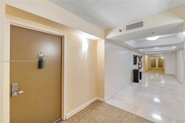 hall featuring a textured ceiling