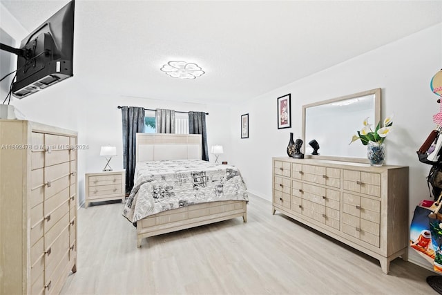 bedroom with light hardwood / wood-style floors and a textured ceiling