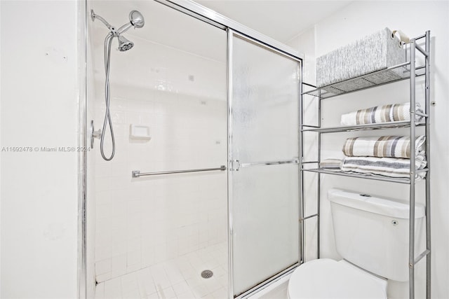 bathroom with a shower with door and toilet