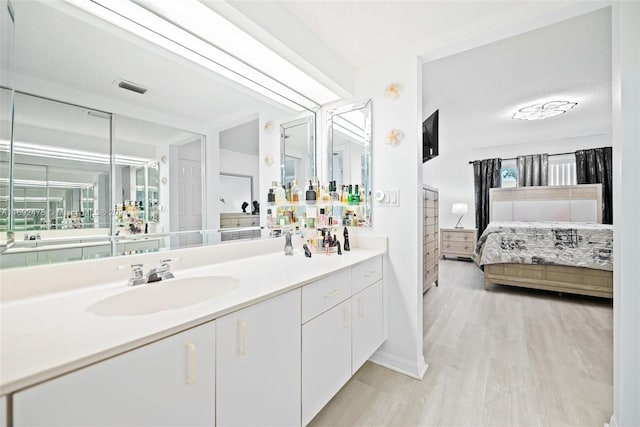 bathroom featuring hardwood / wood-style floors, vanity, and a textured ceiling