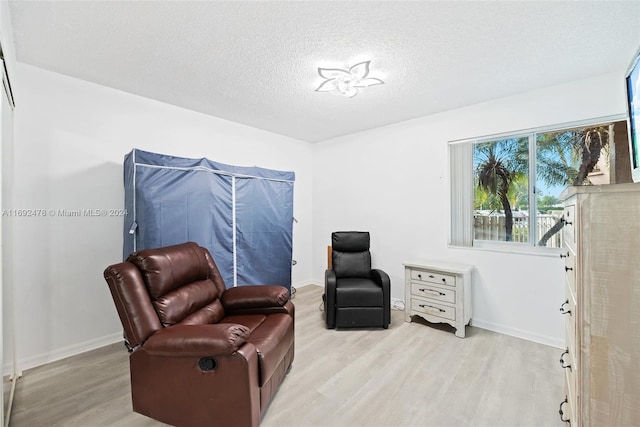 living area with a textured ceiling and light wood-type flooring