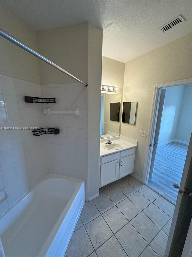 8239 Claire Ann Dr Unit 307, Orlando, FL 32825 - bathroom with a textured ceiling, tile patterned floors, bathing tub / shower combination, and vanity
