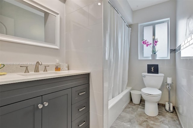 full bathroom with tile walls, vanity, toilet, and shower / bath combo with shower curtain