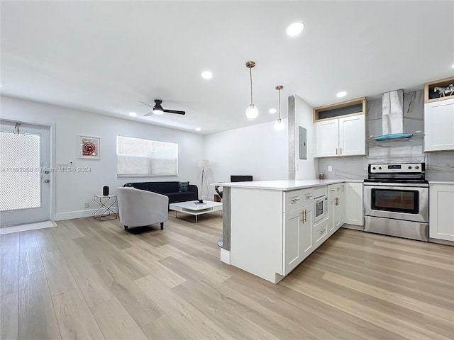 kitchen featuring stainless steel electric stove, kitchen peninsula, wall chimney exhaust hood, light hardwood / wood-style floors, and white cabinetry