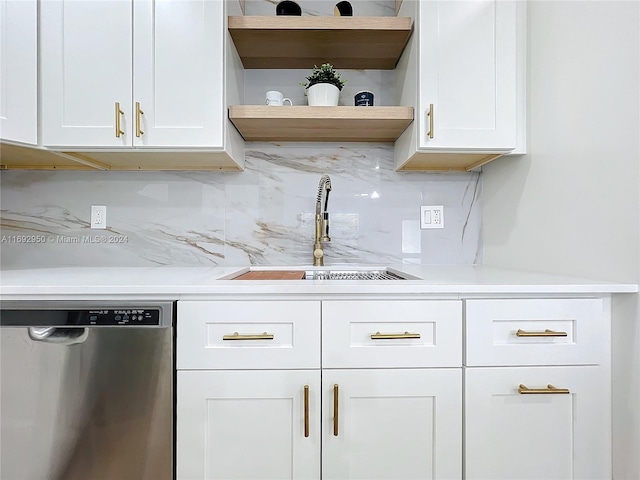 kitchen featuring decorative backsplash, white cabinetry, stainless steel dishwasher, and sink