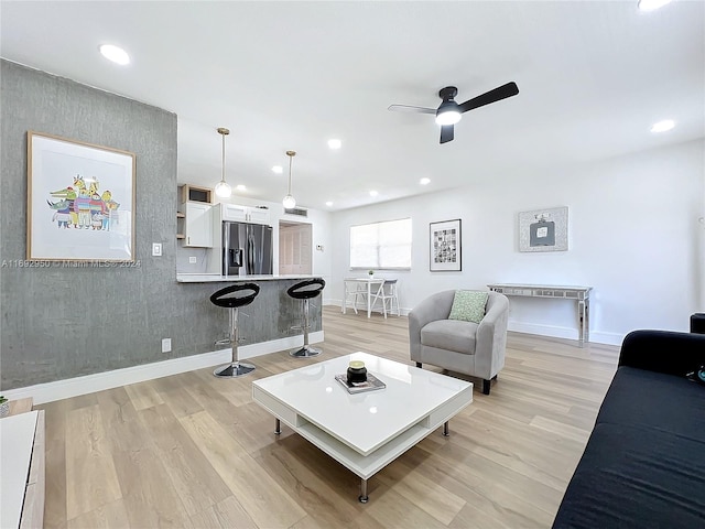 living room with light hardwood / wood-style flooring and ceiling fan