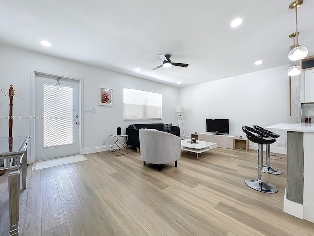 living room featuring ceiling fan and light hardwood / wood-style floors