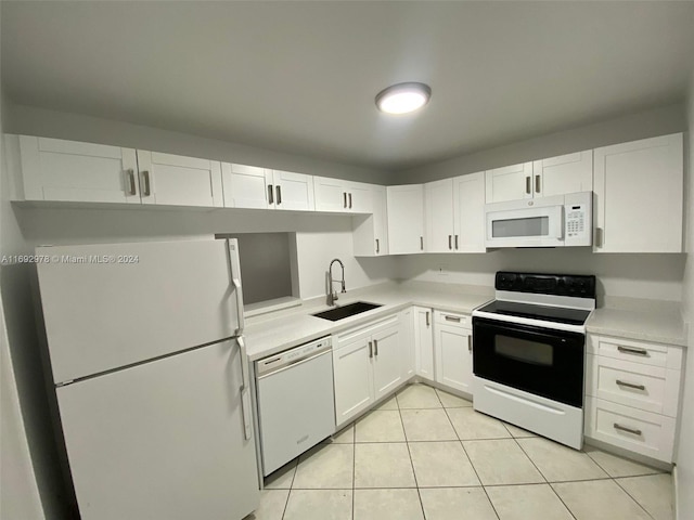 kitchen featuring white cabinets, light tile patterned flooring, white appliances, and sink