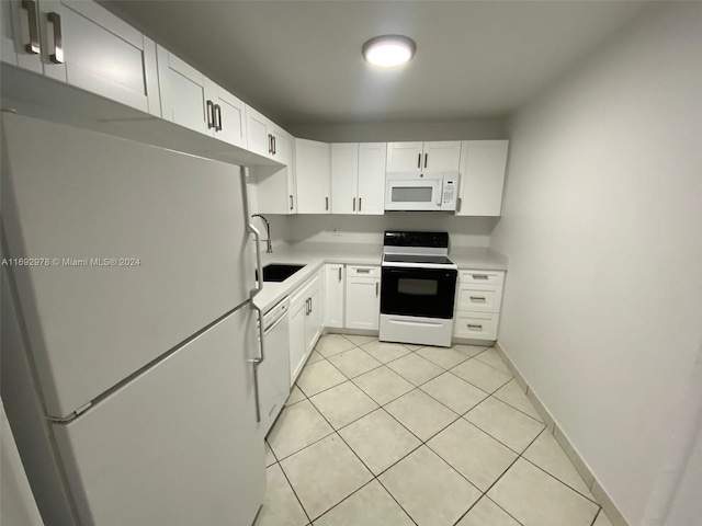 kitchen with white cabinets, white appliances, sink, and light tile patterned floors