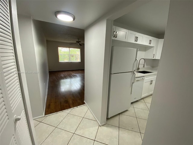 kitchen with white appliances, light wood-type flooring, white cabinetry, and sink