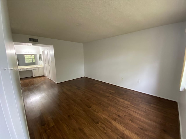 unfurnished living room featuring dark hardwood / wood-style floors and a textured ceiling