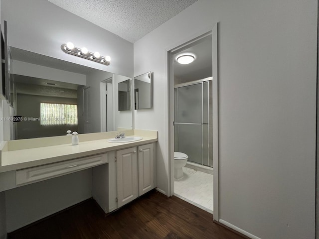 bathroom featuring hardwood / wood-style flooring, vanity, a textured ceiling, and walk in shower