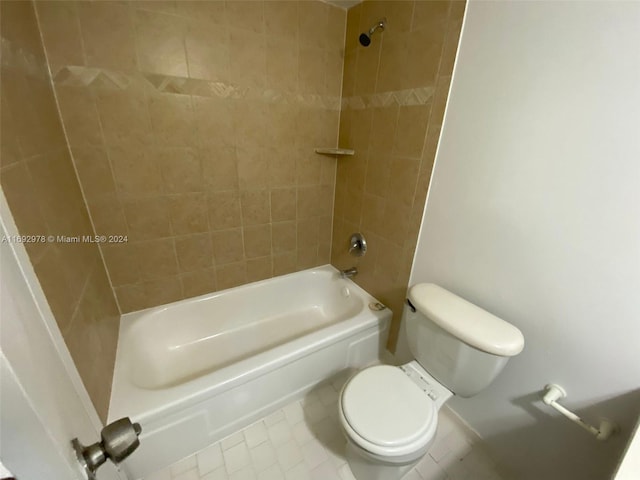 bathroom with toilet, tiled shower / bath combo, and tile patterned floors