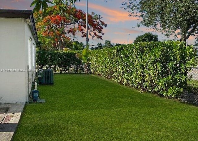 yard at dusk featuring cooling unit