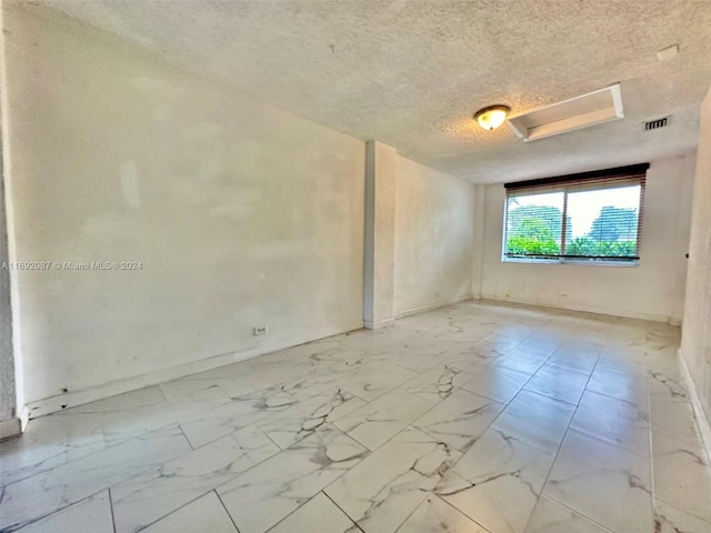 unfurnished room featuring a textured ceiling