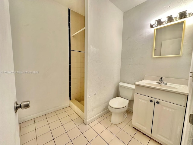 bathroom with vanity, tile patterned floors, toilet, and tiled shower