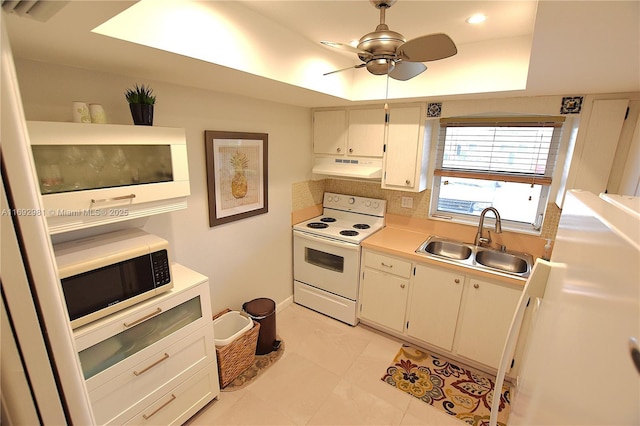 kitchen featuring white cabinets, white appliances, a tray ceiling, and sink