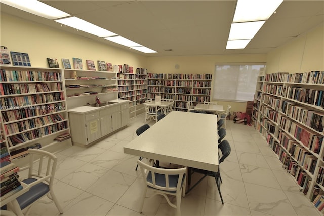2688 E Dudley Dr Unit H, West Palm Beach, FL 33415 - interior space featuring bookshelves, light marble finish floors, and a paneled ceiling