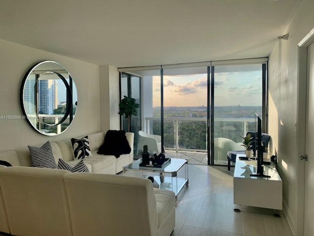 living room featuring a wealth of natural light, floor to ceiling windows, and light hardwood / wood-style flooring