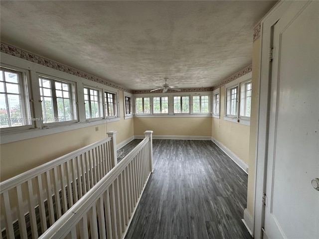 unfurnished sunroom featuring ceiling fan