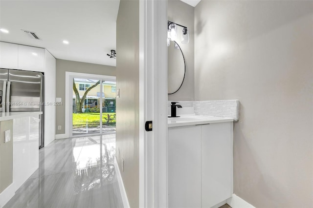 bathroom with vanity, tile patterned floors, and tasteful backsplash