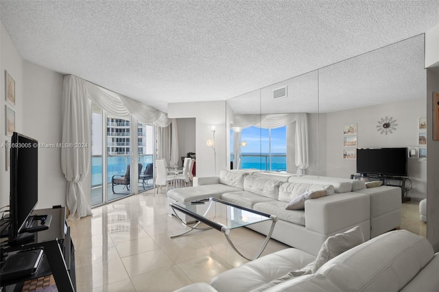 living room with a textured ceiling and light tile patterned floors