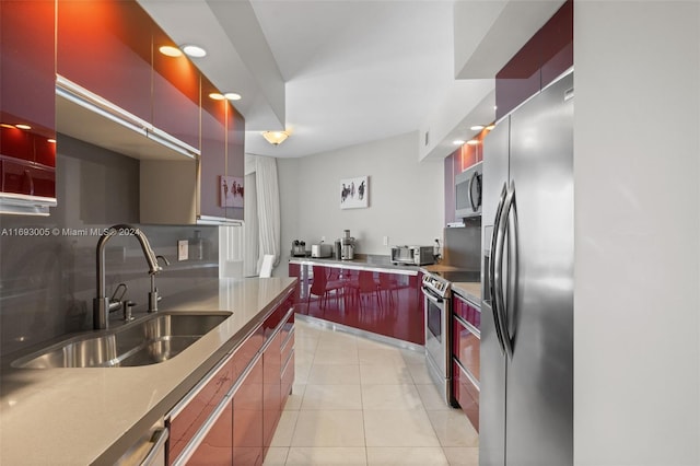 kitchen with appliances with stainless steel finishes, sink, and light tile patterned floors