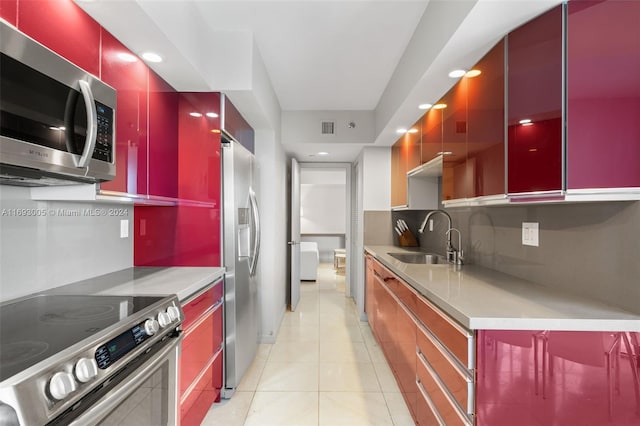 kitchen with light tile patterned floors, sink, backsplash, and appliances with stainless steel finishes