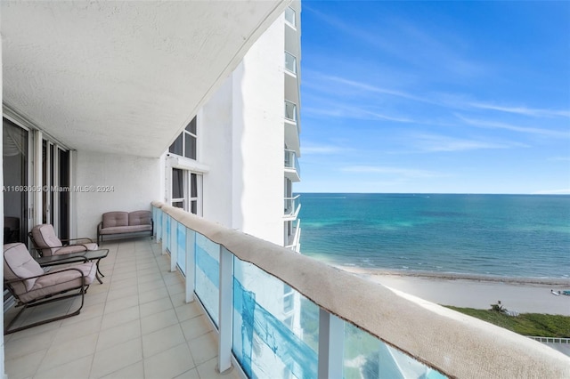 balcony featuring a beach view and a water view