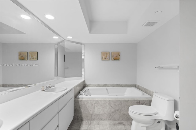 bathroom with a relaxing tiled tub, vanity, and toilet