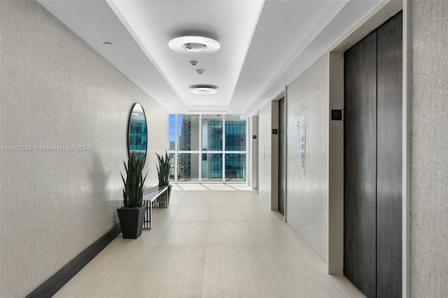 corridor with elevator and floor to ceiling windows