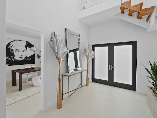 entryway with french doors and a towering ceiling