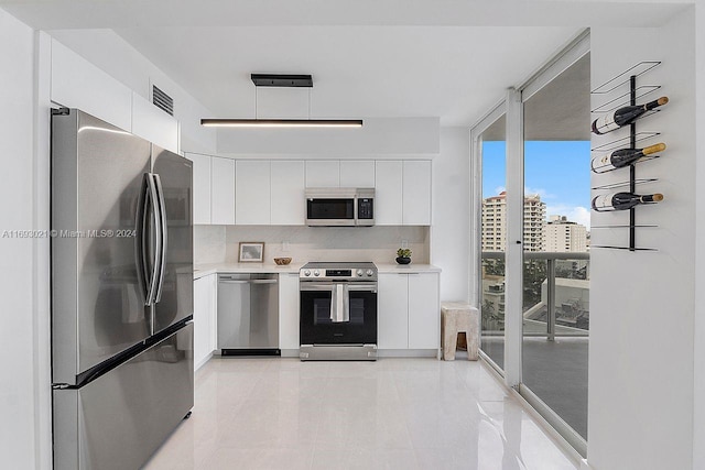 kitchen featuring stainless steel appliances, white cabinets, backsplash, and floor to ceiling windows