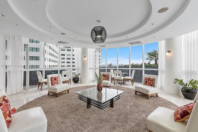 living room featuring a wall of windows and a tray ceiling