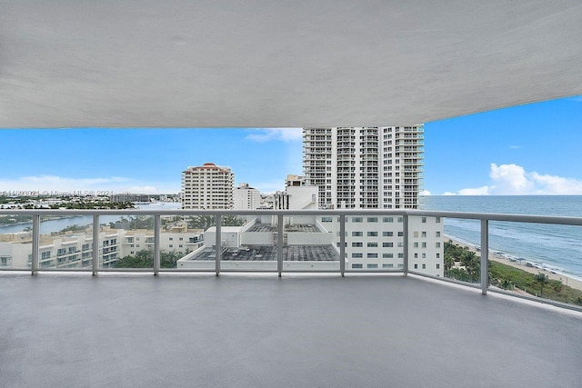 balcony featuring a water view and a beach view