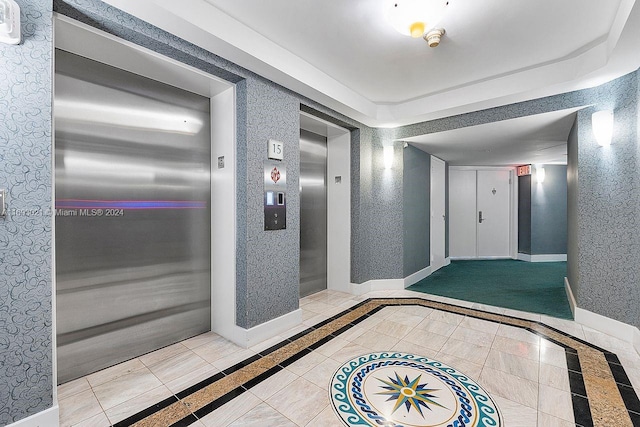 6301 Collins Ave Unit 1508, Miami Beach, FL 33141 - hall featuring elevator, inlaid floor details, and baseboards