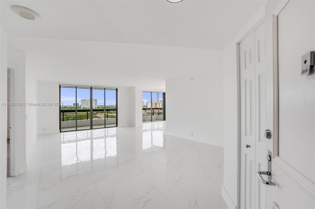 unfurnished room featuring a wall of windows