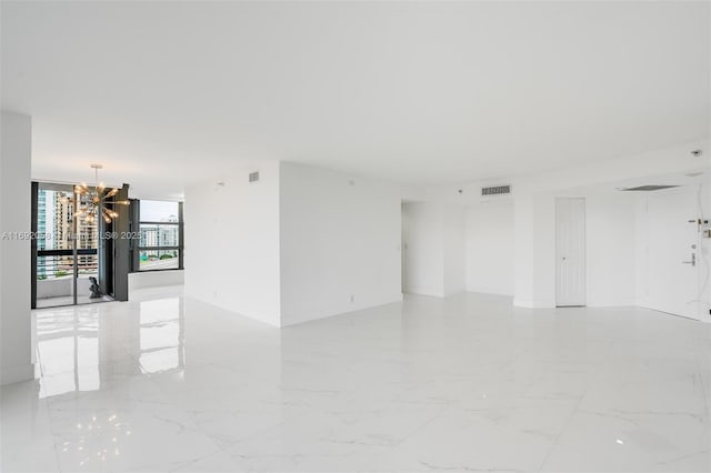 empty room with a notable chandelier and floor to ceiling windows