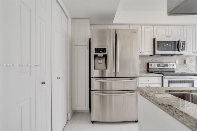 kitchen with light stone countertops, marble finish floor, white cabinetry, and appliances with stainless steel finishes