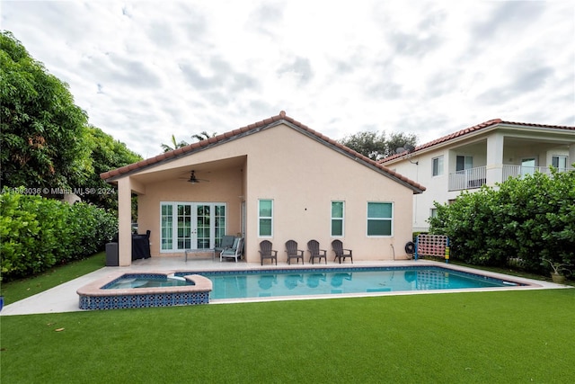 rear view of property with a pool with hot tub, a patio, ceiling fan, and a lawn