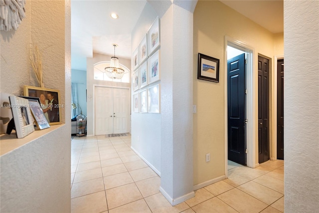 hall featuring a notable chandelier and light tile patterned floors