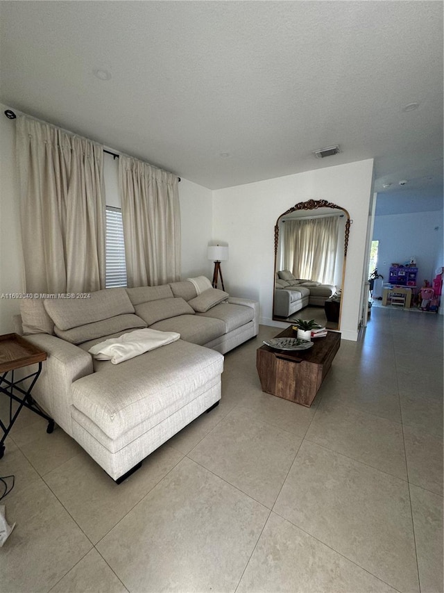 tiled living room with plenty of natural light and a textured ceiling